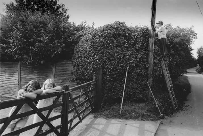 L-R. Jessica Baker & Alice Wilson. Brian Davey cutting his hedge. Ambury Road.